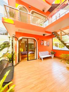 Cette chambre orange dispose d'un balcon avec un banc et des escaliers. dans l'établissement TGlobal Nguyễn Tất Thành Street Tam Đảo, à Tam Ðảo