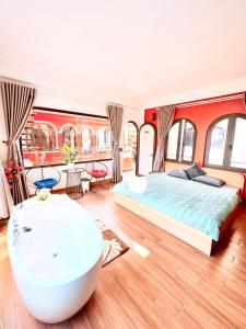 a bedroom with a large bed and a bath tub at TGlobal Nguyễn Tất Thành Street Tam Đảo in Tam Ðảo
