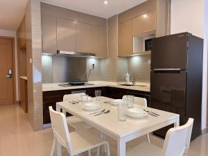 eine Küche mit einem weißen Tisch mit Stühlen und einem Kühlschrank in der Unterkunft Luxury 2Bedroom R&F Princess Cove @By Hauz Cinta in Johor Bahru