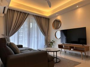 ein Wohnzimmer mit einem Sofa und einem Flachbild-TV in der Unterkunft Luxury 2Bedroom R&F Princess Cove @By Hauz Cinta in Johor Bahru