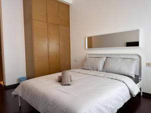 a bedroom with a white bed with a cabinet at Luxury 2Bedroom R&F Princess Cove @By Hauz Cinta in Johor Bahru