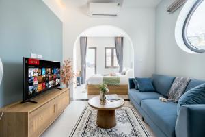 a living room with a blue couch and a tv at Crescendo Boutique Studio in Hanoi