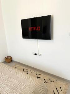 uma televisão de ecrã plano pendurada numa parede branca em ארץ מדבר - יחידת אירוח בבאר אורה em Beʼer Ora