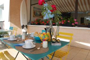 une table bleue avec des assiettes, des tasses et des fleurs dans l'établissement Le Pont de la Loire, à Bourbon-Lancy