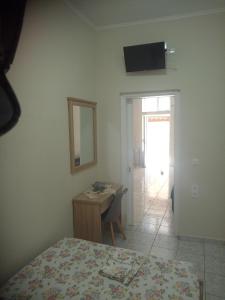 a bedroom with a bed and a desk and a mirror at tom house 2 in Filiatra