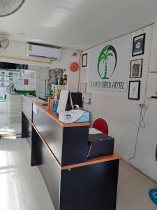 un comptoir dans un petit hôtel vert avec un panneau sur le mur dans l'établissement Samui Green Hotel, à Chaweng