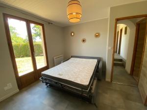 ein Schlafzimmer mit einem Bett in einem Zimmer mit einem Fenster in der Unterkunft Maison Calme avec extérieur 