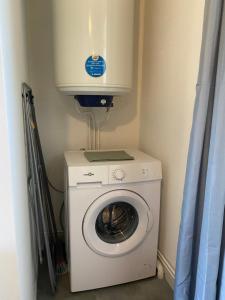 Waschmaschine und Trockner in einer Ecke eines Zimmers in der Unterkunft Maison Calme avec extérieur 