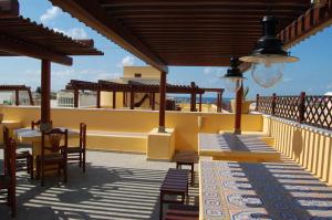 a patio with tables and chairs on a roof at El Mosaico Del Sol in Lampedusa
