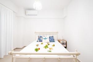 a white bedroom with a white bed with flowers on it at Ennea suites-Earth suite in Flámbouras +4 photos