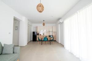 Ennea suites-Earth suite في Flámbouras: غرفة معيشة ومطبخ مع أريكة وكراسي