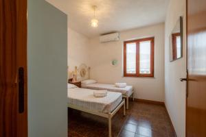 een ziekenhuiskamer met 2 bedden en een raam bij [5 Min Budoni]Terrazzo Vista Borgo & Self Check-In in Tanaunella