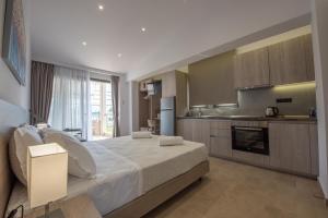 a bedroom with a large bed and a kitchen at Casa de Lapel Kallithea in Kallithea Halkidikis