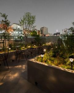 a rooftop patio with chairs and lights and a city at Dawn House in Seoul