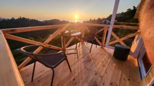 two chairs and a table on a deck with the sunset at VILLA GANTIADI in Batumi