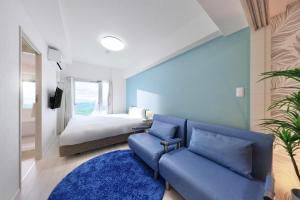 a living room with a couch and a bed at Crystal Exe Nanki Shirahama 1 in Shirahama