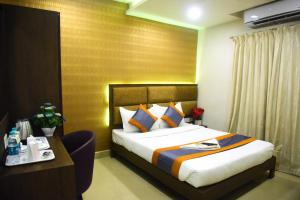 Habitación de hotel con cama, escritorio y cama sidx sidx en Pine Tree Signature en Chennai
