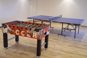 two ping pong tables in a room with two tables at Urban Lifestyle 1BR in Westlands, Heated Pool, Gym, Workspace & Parking in Nairobi