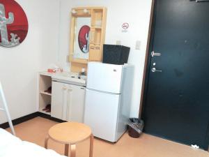 a small kitchen with a white refrigerator and a table at COTE sakuragawa "Room 201,301,401" - Vacation STAY 03144v in Osaka
