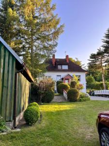 una casa blanca con una valla y un patio en Agroturystyka „U Rzeźbiarza”, en Sławno