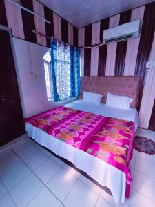 a bedroom with a large bed with a pink blanket at Hotel India inn in Agra
