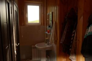 een kleine badkamer met een wastafel en een raam bij Woody Guest House Nursultan in Kaindy
