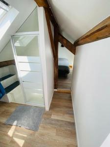 a attic room with a glass door and a bedroom at Joli Duplex à quelques pas du centre de Bayonne in Bayonne