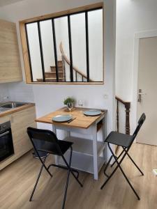 une table et des chaises dans une cuisine avec une fenêtre dans l'établissement Joli Duplex à quelques pas du centre de Bayonne, à Bayonne