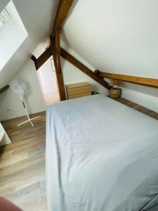 een slaapkamer met een wit bed op zolder bij Joli Duplex à quelques pas du centre de Bayonne in Bayonne