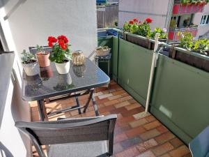 a table and chairs on a balcony with potted plants at Ferienwohnung Schallinger in Teisendorf