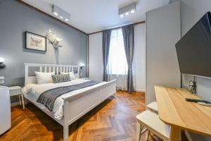 um quarto com uma cama, uma secretária e uma televisão em My Place Ferdinand em Cluj-Napoca