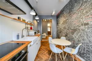a kitchen with a table and chairs in front of a wall at My Place Ferdinand in Cluj-Napoca