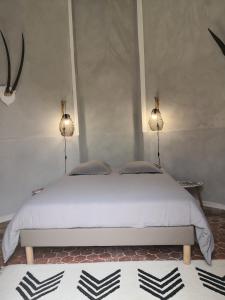 um quarto com uma cama branca com duas luzes em Gite La Tourelle Château de Montchevreau em Cosne Cours sur Loire
