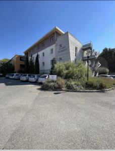 普罗旺斯艾克斯Joli Studio le clos d'Aix avec grande terrasse piscine et parking gratuit的一栋建筑物，停车场里停着几辆车