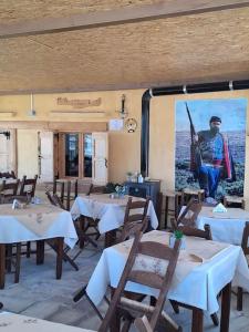 a restaurant with tables and chairs with a picture of a man at Fully equipped apartment in Apokoronas in Nípos