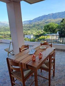 a wooden table and chairs on a porch with a view at Fully equipped apartment in Apokoronas in Nípos