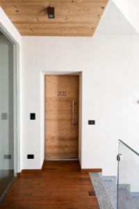 un corridoio con porta in legno in una casa di Grey Castle garnì&suite a Ponte di Legno