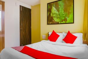 a bedroom with a large bed with red pillows at OYO Flagship I- Siri Lodge in Pune