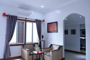 a living room with two chairs and a window at Villa b.Maison d'Hôtes Angkor in Siem Reap