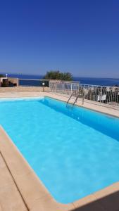バスティアにあるAppartement de 2 chambres avec vue sur la mer piscine privee et terrasse amenagee a Bastia a 2 km de la plageの海を背景にした青い大型スイミングプール