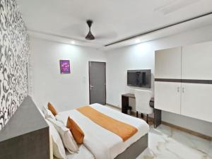 um quarto com uma cama, uma secretária e uma televisão em Flexi Hospitality - A Star - अमृतसर का सबसे Premium होटल em Amritsar
