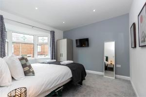 a bedroom with a large bed and a window at Stunning newly decorated House - TV in each Bedroom in Darlington