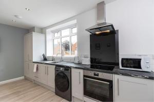 a kitchen with a stove and a microwave at Stunning newly decorated House - TV in each Bedroom in Darlington