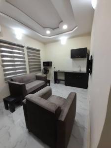 a living room with couches and a flat screen tv at F and B serviced apartment Abeokuta in Aro