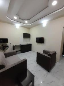 a living room with two couches and two monitors at F and B serviced apartment Abeokuta in Aro