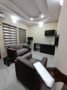 a living room with two couches and a tv at F and B serviced apartment Abeokuta in Aro