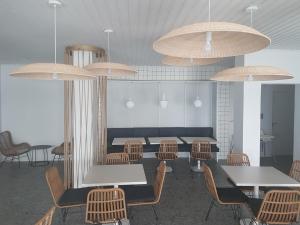 una sala da pranzo con tavoli, sedie e luci a ciondolo di E.J. Pyrgos Bay Hotel a Kato Pyrgos