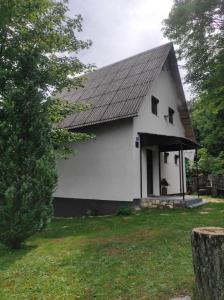 a white house with a gambrel roof at Kuća za odmor Iva in Lič