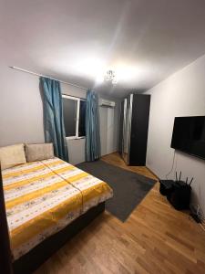 a bedroom with a bed and a flat screen tv at Chaika Sea Apartment in Varna City