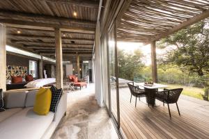 a patio with a couch and a table on a deck at Kapama Karula in Kapama Private Game Reserve
